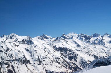Arka planda Elbrus Dağı ile karlar kaplandı. Kış mevsiminde Dombay ve Kafkasya Dağları 'ndan manzara.