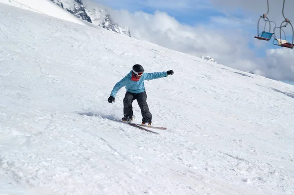 Snowboardos Ugrás Havas Sípálya Régi Szék Lift Kék Göröngyös Háttérben — Stock Fotó