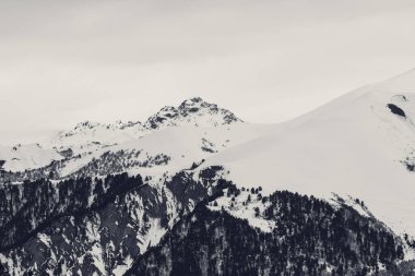Kar altında dağlar ve kış akşamı bulutlu gri gökyüzü. Kafkasya Dağları, Gürcistan 'ın Svaneti bölgesi. Siyah ve beyaz tonlu manzara
