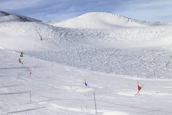 晴れた冬の日に雪の多い山の中で雪猫とオフスキー場の斜面によって調製されたフラグでマークされたゲートとスキースラロームのためのトレース イタリアアルプス ロンバルディア州 イタリア ヨーロッパの地域 — ストック写真