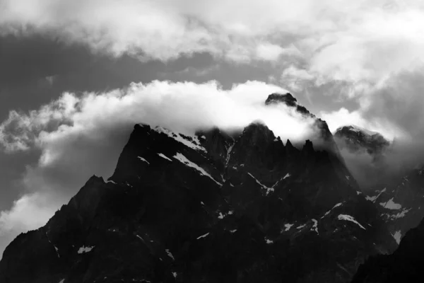 Black and white rocks with snow in clouds. Caucasus Mountains, Georgia, region Svaneti.