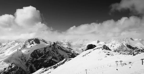 在阳光灿烂的日子里 滑雪场和多云的高山上的黑白全景尽收眼底 高加索山脉冬季 东湾地区 — 图库照片
