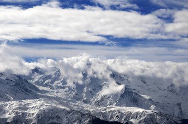 Kar kış dağları güneş ışığında bulutların içinde. Kafkas Dağları. Gürcistan 'ın Svaneti bölgesi.