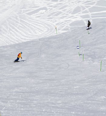 İki snowboardcu, güneşli soğuk bir günde karlı bir havada yokuş aşağı gidiyorlar. Kışın Kafkasya Dağları, Gürcistan, Gudauri bölgesi.