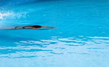 Açık havuzda yüzen bir kadın güzel, berrak bir suyla güzel bir yaz günü