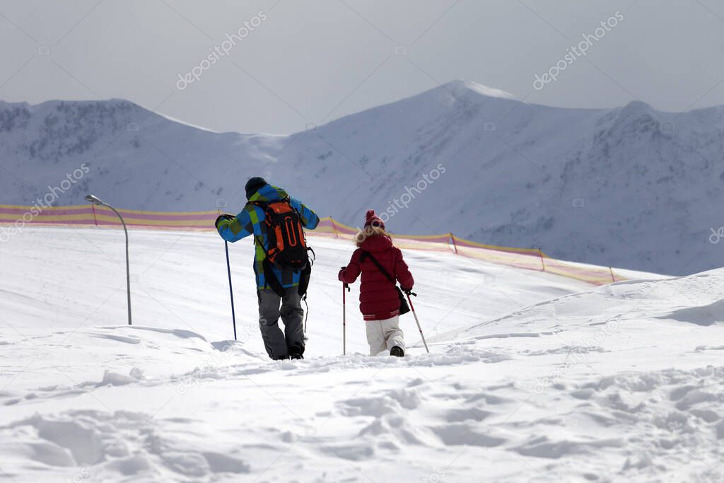 Father and daughter on ski resort after snowfall in sun day. Caucasus Mountains, Georgia, region Gudauri at winter.