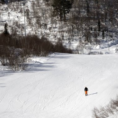 Skier on snowy ski slope at sunny winter day. Caucasus Mountains. Hatsvali, Svaneti region of Georgia. Square image.