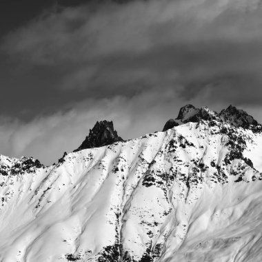 Snowy avalanches mountainside at sunny day. View from chair lift on Hatsvali, Svaneti region of Georgia. Caucasus Mountains. Black and white toned landscape. Square image.