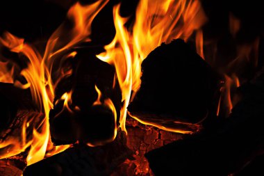 Fireplace with burning wood and forks of flame. Close-up view. clipart