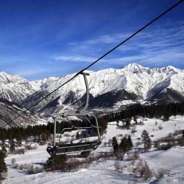 Kayak merkezinde sandalye kaldırma ve güneşli bir günde karlı kış dağları. Kafkas Dağları. Hatsvali, Gürcistan 'ın Svaneti bölgesi. Kare resim.