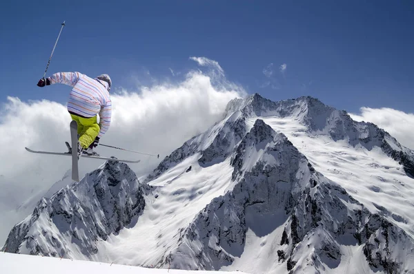 Freestyle Skispringer Mit Gekreuzten Skiern Hohen Schneebedeckten Bergen Sonnigen Wintertag — Stockfoto