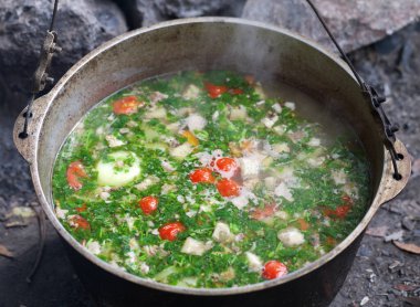 Kamptaki kazanda taze pişmiş sıcak çorba var. Açık hava yemekleri..