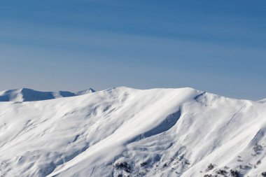 Güneş akşamında çığ yüzünden oluşan karlı güneş ışığı yamacına bakın. Kafkasya Dağları, Gürcistan, Gudauri bölgesi kışın.
