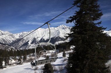 Spruce, kayak merkezinde sandalye kaldırma ve güneşli bir günde karlı kış dağları. Kafkas Dağları. Hatsvali, Gürcistan 'ın Svaneti bölgesi.