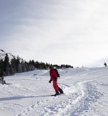 Kar sörfçüsü kış sabahı kar yamaçlarında yokuş aşağı iniyor. Karpat Dağları, Ukrayna.
