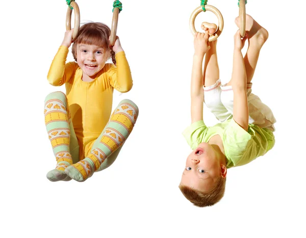 Crianças brincando e se exercitando em anéis de ginástica Fotografia De Stock
