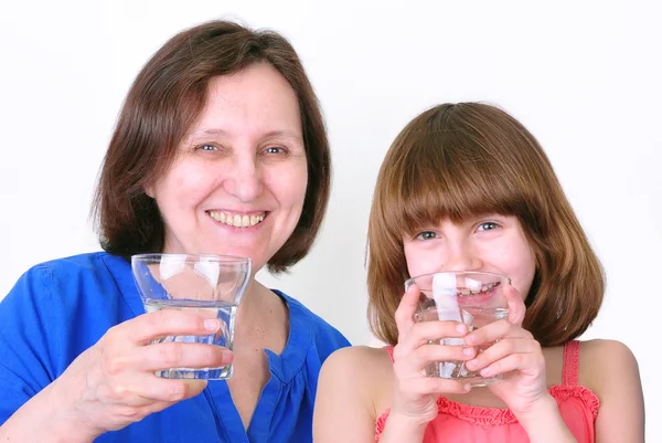 Smiling woman and girl drink water — Stock Photo, Image