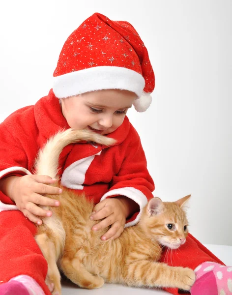 Рождественский ребенок играет с котом — стоковое фото