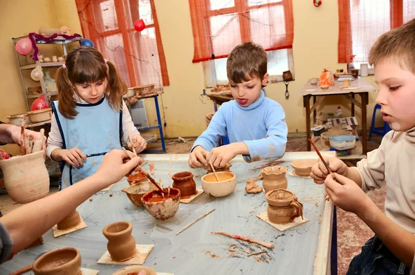 Group of children decorating their clay pottery — Stock Photo, Image