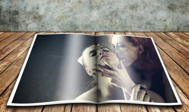 Vampire's kiss. Glossy magazine over wooden desk clipart