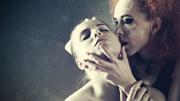 Beijo de vampiro. Fantasia retrato feminino contra escuro grungy de volta — Fotografia de Stock