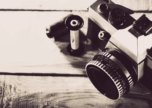 Vintage 35 mm film photo camera over wooden desk — Stock Photo, Image