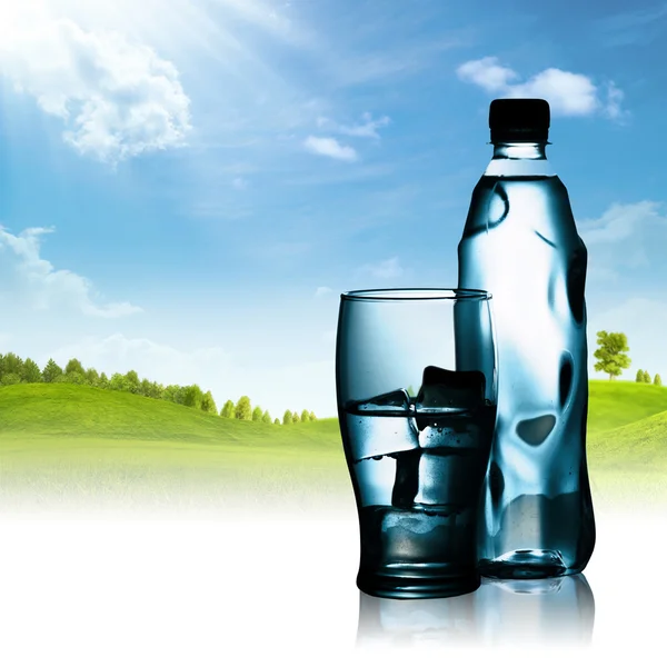 Spring mineral water bottled with glass and ice against natural — Stock Photo, Image