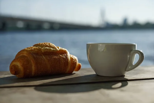 川の岸で朝 テーブルの上においしい香りのコーヒーのカップ — ストック写真