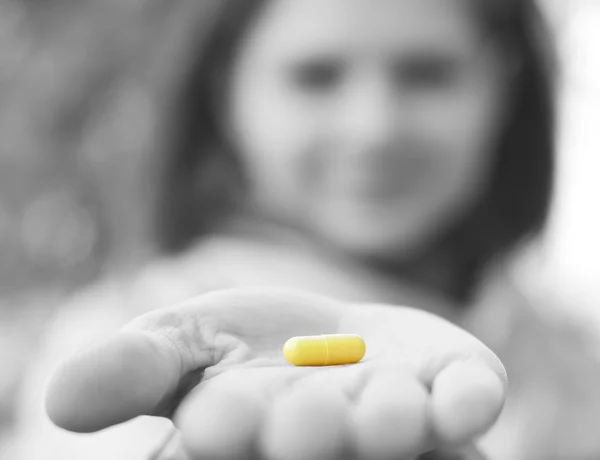 Woman holds a pill in a hand — Stock Photo, Image
