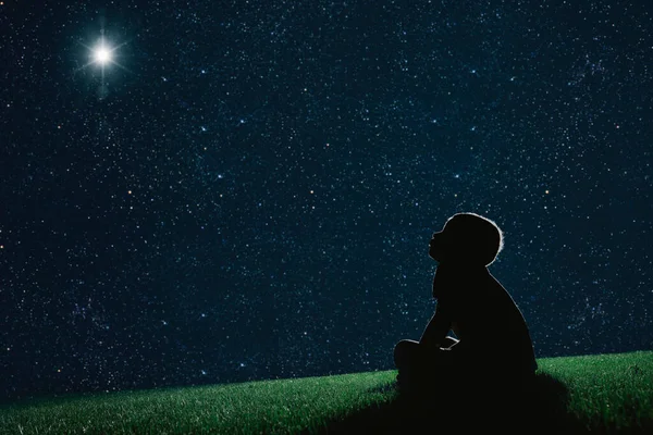 Παιδί Κάθεται Στο Γρασίδι Βράδυ Και Δούμε Χριστουγεννιάτικο Ουρανό Νύχτα — Φωτογραφία Αρχείου