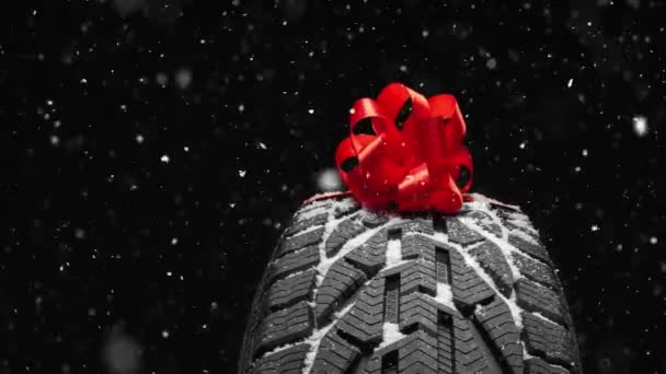 Schwarzer Isolationsgummireifen Auf Dem Grauen Hintergrund Einer Schleife Für Weihnachten — Stockvideo