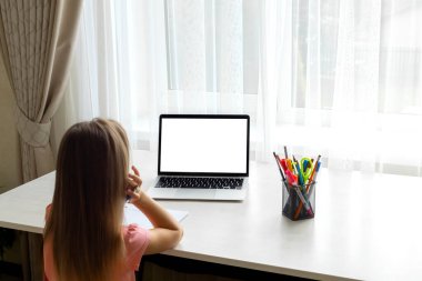 school at home through online homeschooling. the child is sitting at the compute