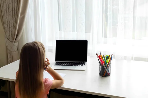 school at home through online homeschooling. the child is sitting at the compute