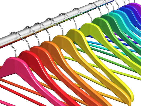 Cabides de capa de arco-íris em trilhos de roupas — Fotografia de Stock