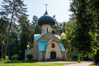 Eski kilise ve ağaçlarla dolu bir manzara.