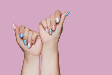 Geometry nail art design in white and blue colors on pink background
