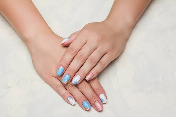 Geometry nail art design in white and blue colors on light background