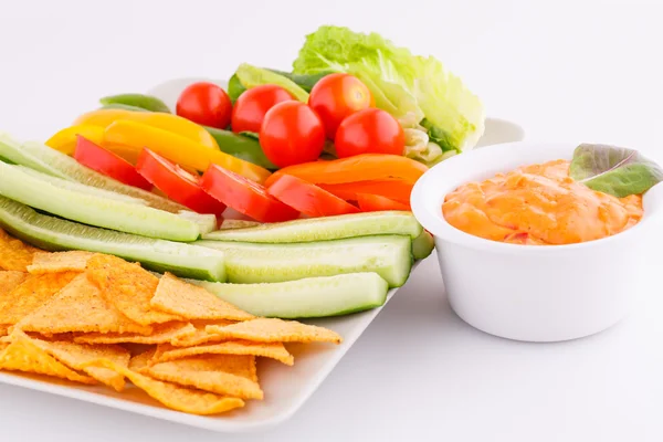 Начос, овощи и сырный соус — стоковое фото