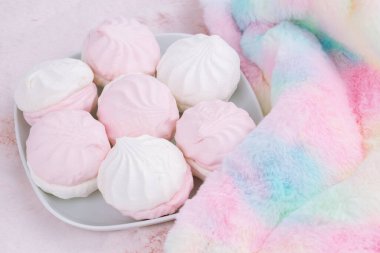 Beyaz tabakta Rus tatlı zefiri ya da zephyr ve pembe arkaplanda renkli kürk eşarbı. Marshmallow yakın çekim resmi. 