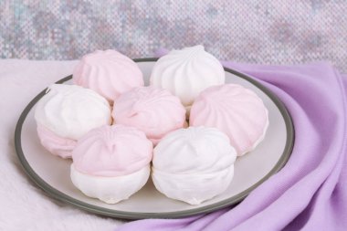 Rus tatlı zefiri ya da pembe kürk arka planında gri tabakta zephyr. Marshmallow ve leylak kaşmir eşarp yakın çekim resmi. Kaşmir atkı..