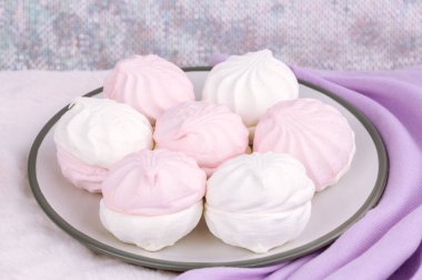 Rus tatlı zefiri ya da pembe kürk arka planında gri tabakta zephyr. Marshmallow ve leylak kaşmir eşarp yakın çekim resmi. Kaşmir atkı..