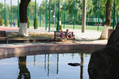 küçük kardeşim ve kız kardeşi bankta oturan