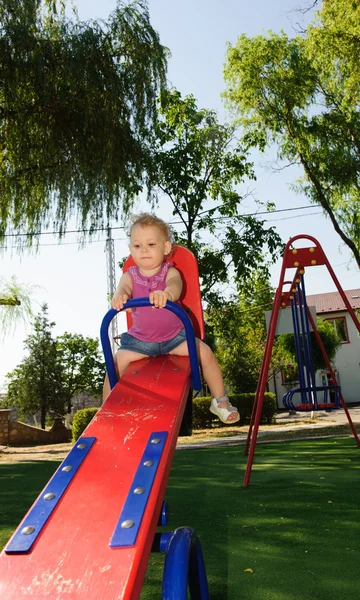 Кучерява блондинка на дитячому майданчику — стокове фото