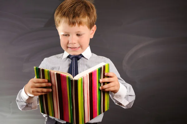 Schattige jongen tegen schoolbord — Stockfoto