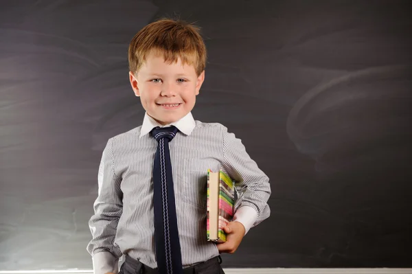 Schattige jongen tegen schoolbord — Stockfoto