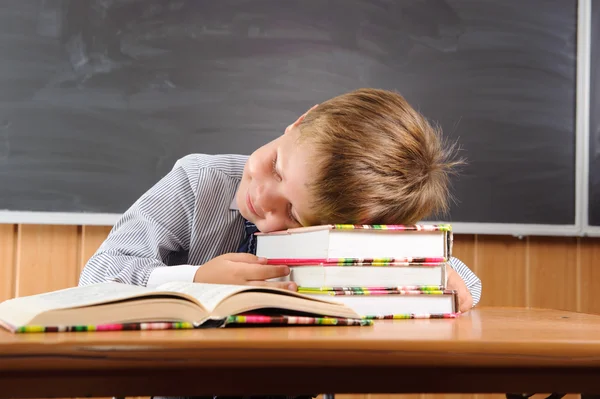 Ragazzo addormentato con libri alla scrivania — Foto Stock