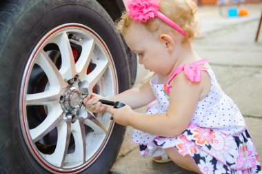 Lillte child playing in auto mechanic clipart