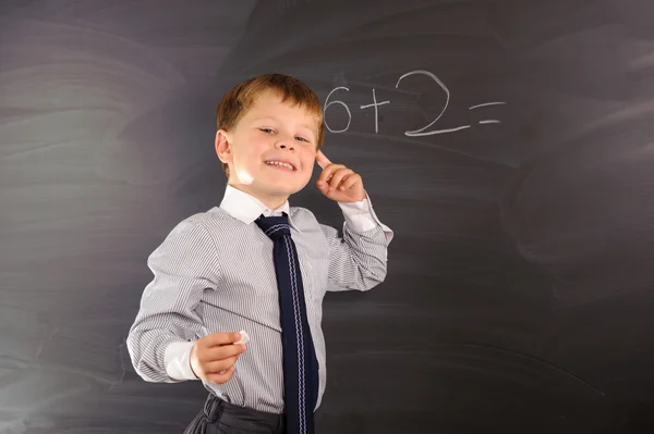 Cute boy against blackboard — Stock Photo, Image