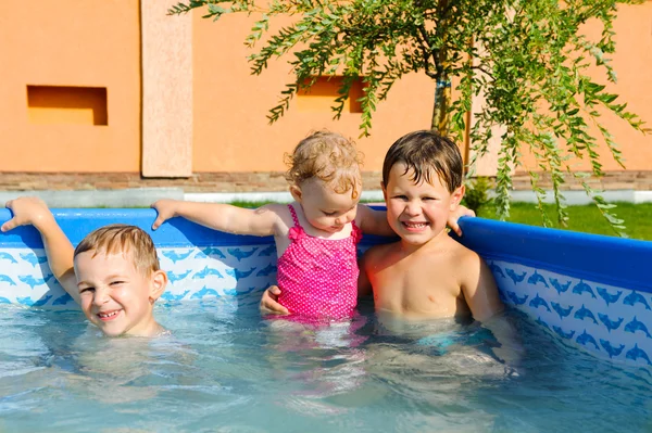 Two brothers and baby sister in the pool — Stock Photo, Image