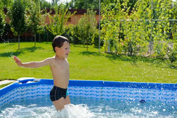 Rapaz bonito pulando na piscina — Fotografia de Stock